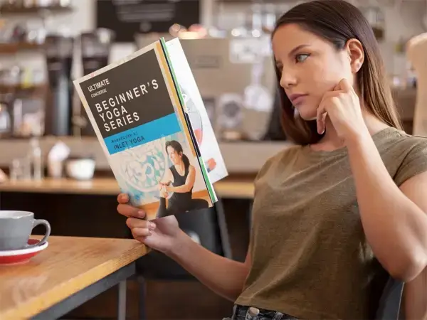 A girl reading beginners yoga guide.