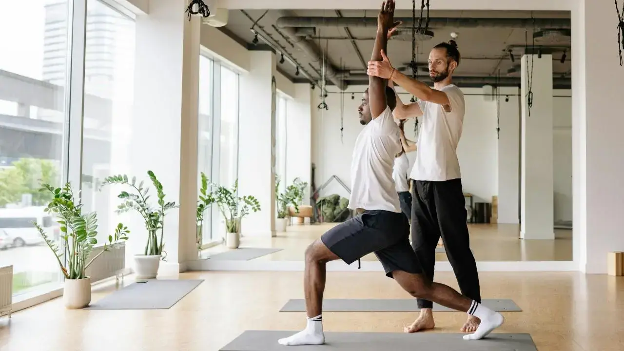 Gemini said A yoga instructor assists a student in a lunge during private yoga classes in a bright, modern studio.