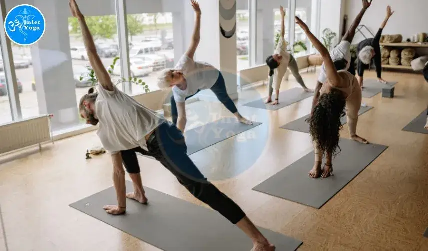 Beginners yoga class at Inlet Yoga Studio in Manasquan NJ with students practicing a side stretch on mats