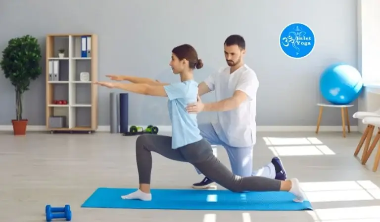 Certified Yoga Instructor guiding student through a supported low lunge during yoga teacher training